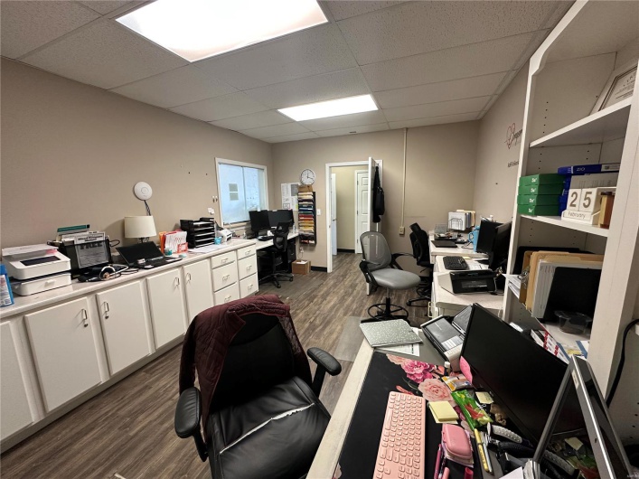 Office featuring dark wood-type flooring and a paneled ceiling