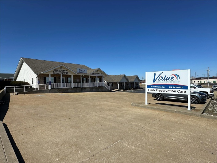View of building exterior with uncovered parking