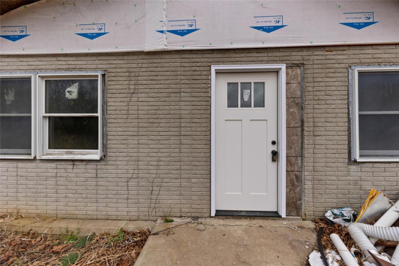 View of exterior entry with brick siding