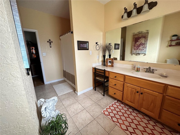Bathroom with baseboards, curtained shower, tile patterned flooring, and vanity