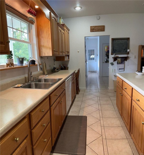 Kitchen featuring light countertops, recessed lighting, a sink, light tile patterned flooring, and dishwasher