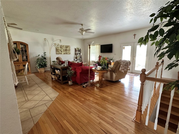Living room featuring a textured ceiling, ceiling fan, and hardwood flooring