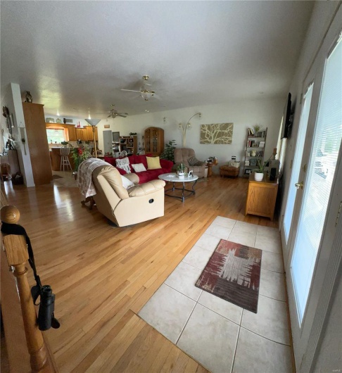Living area with light wood flooring and ceiling fan