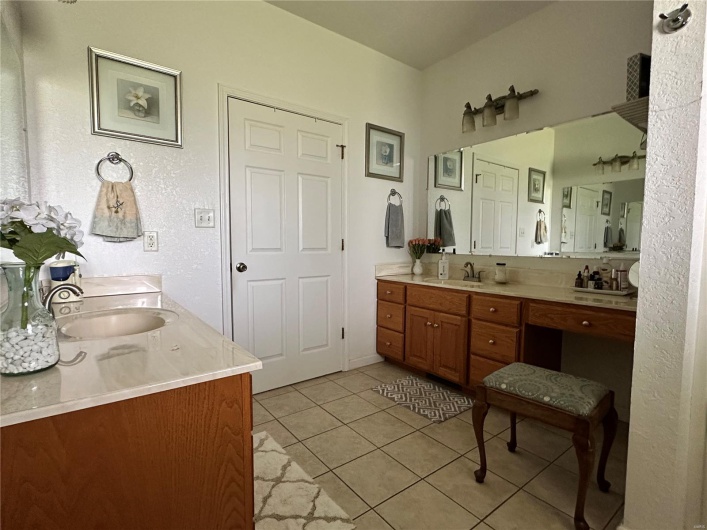 Full bath featuring tile patterned flooring, a sink, and two vanities