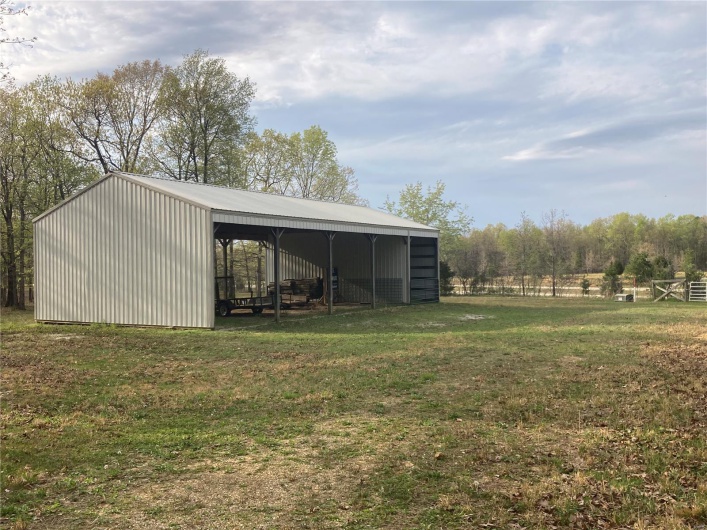 View of pole building featuring a carport and a lawn