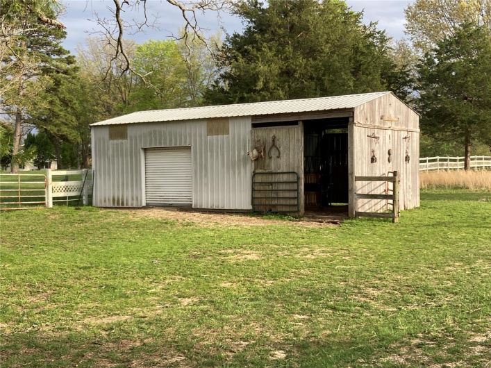 View of pole building with a yard and fence