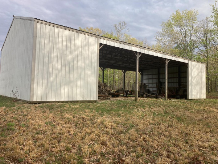 View of pole building with a yard