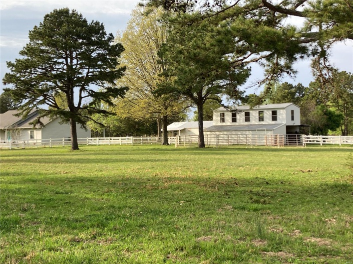 View of yard featuring a barn, fence, and an outdoor structure