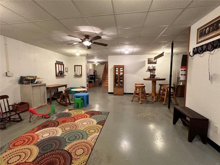 Finished basement featuring a paneled ceiling and a ceiling fan