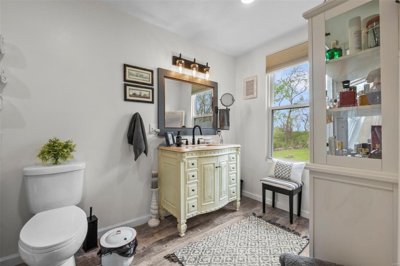 Bathroom with baseboards, wood finished floors, toilet, and vanity