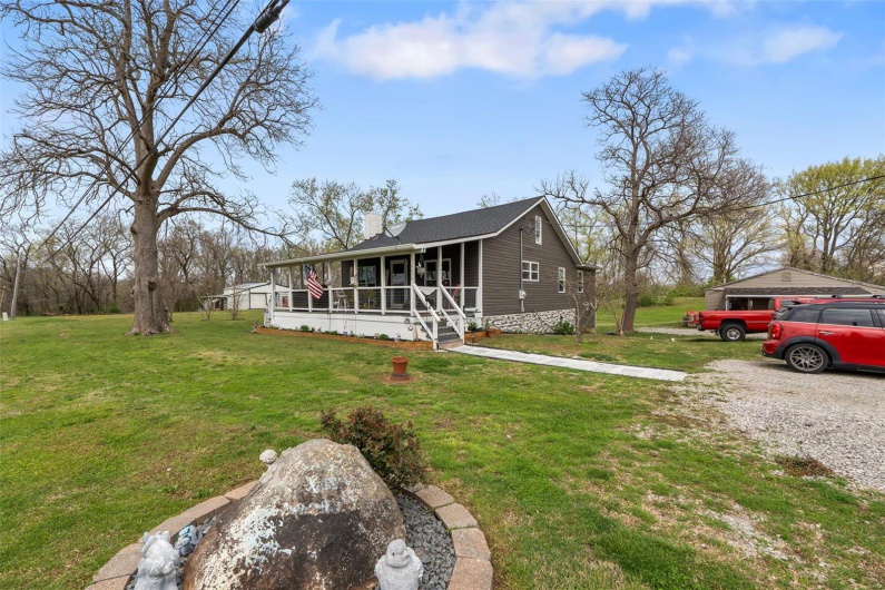 View of front facade with a chimney, a porch, and a front yard