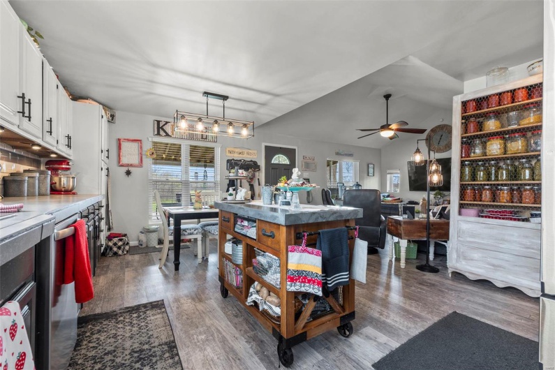 Kitchen featuring dark wood finished floors, white cabinets, a ceiling fan, and plenty of natural light