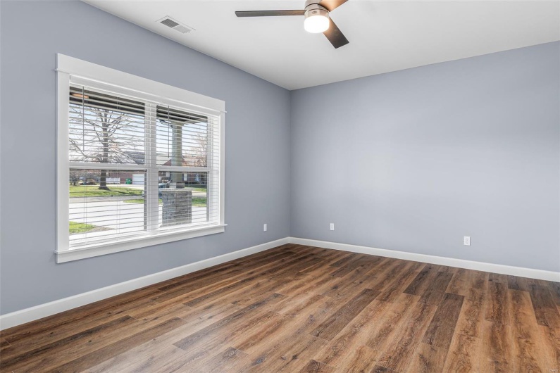 Unfurnished room featuring a ceiling fan, visible vents, baseboards, and wood finished floors