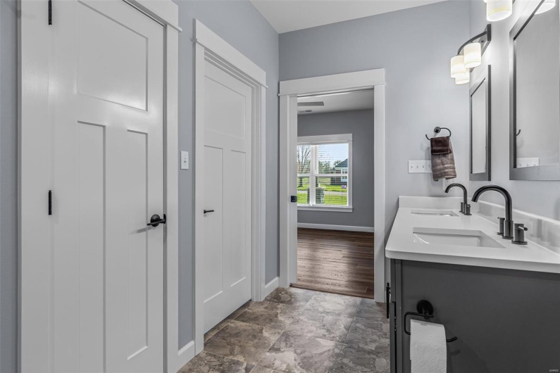 Bathroom with double vanity, a sink, and baseboards