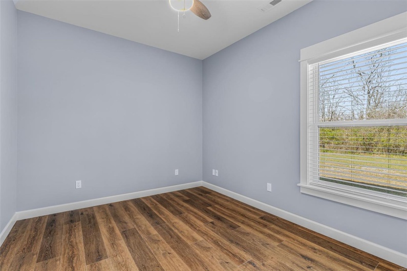 Spare room featuring visible vents, baseboards, ceiling fan, and dark wood finished floors