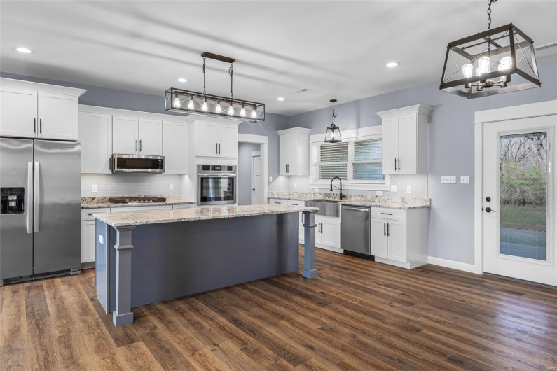 Kitchen with white cabinetry, appliances with stainless steel finishes, and a kitchen island