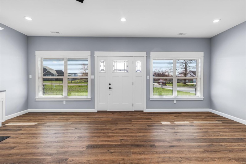 Foyer featuring visible vents, dark wood-style floors, and a wealth of natural light