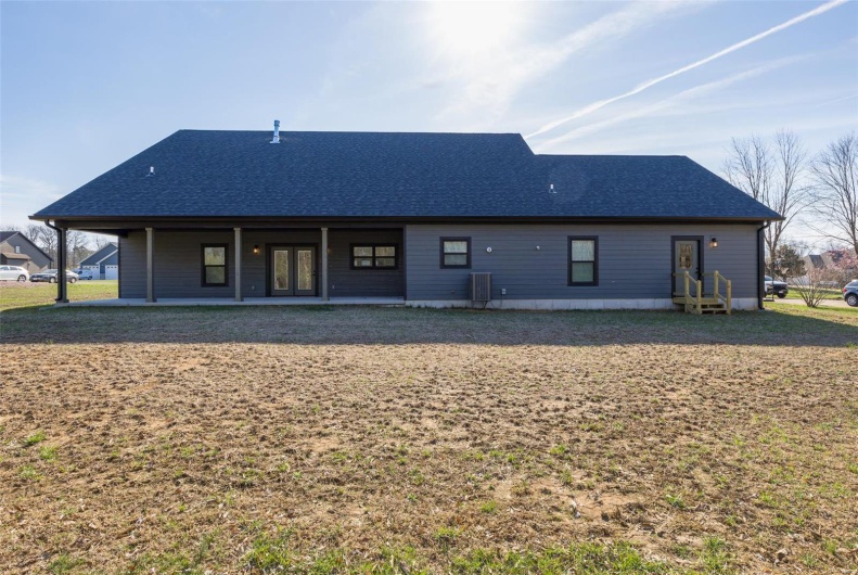 Back of house featuring a shingled roof
