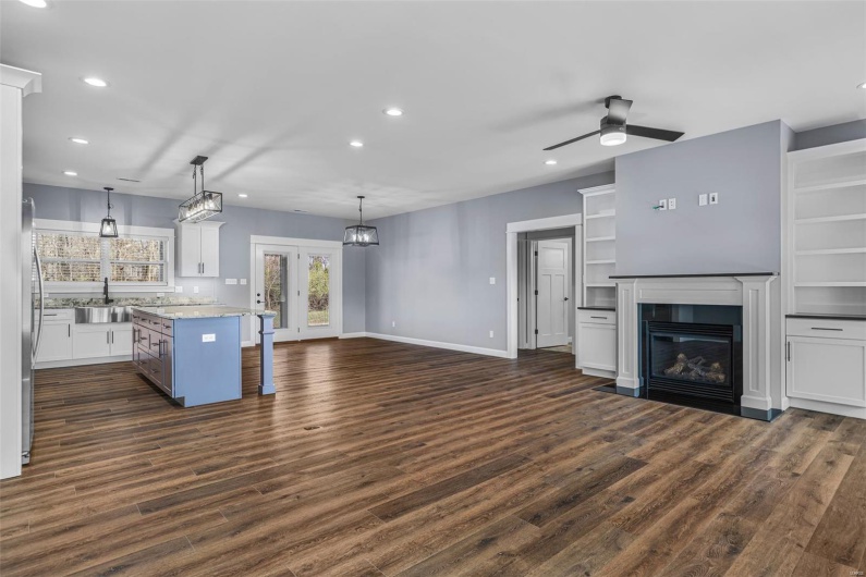 Kitchen with dark wood-style flooring, white cabinets, a sink, and recessed lighting