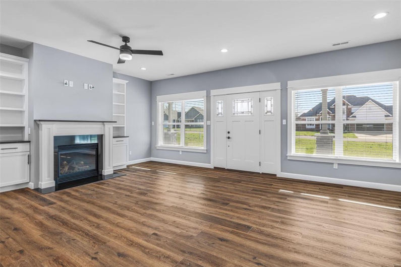 Unfurnished living room featuring baseboards, dark wood-style flooring, visible vents, and recessed lighting