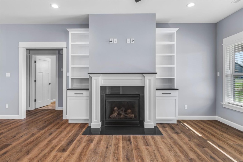 Unfurnished living room with baseboards, dark wood-style flooring, a fireplace with flush hearth, and recessed lighting
