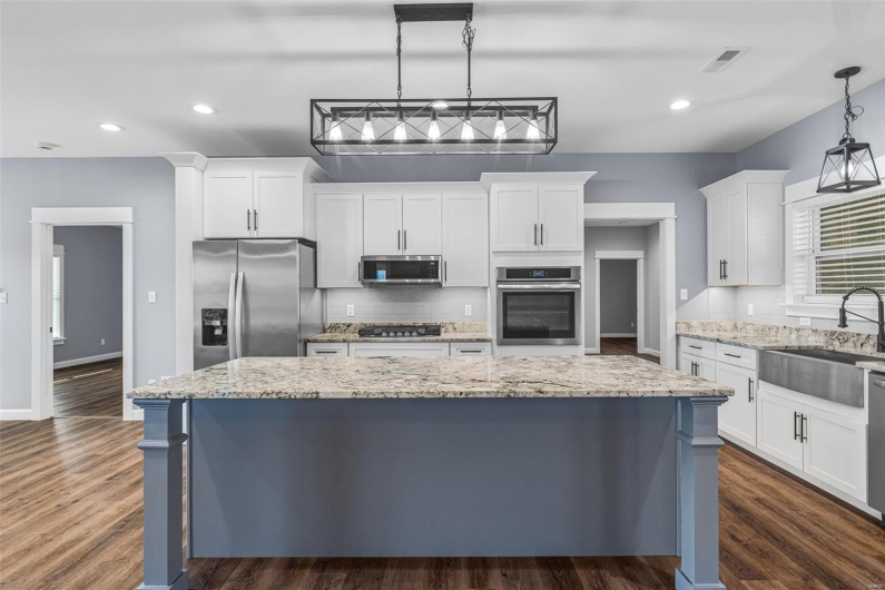 Kitchen with white cabinetry, dark wood-style floors, a sink, and appliances with stainless steel finishes
