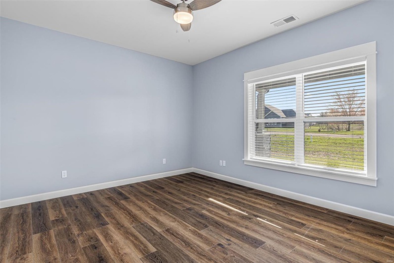 Unfurnished room with baseboards, visible vents, a ceiling fan, and dark wood-style flooring