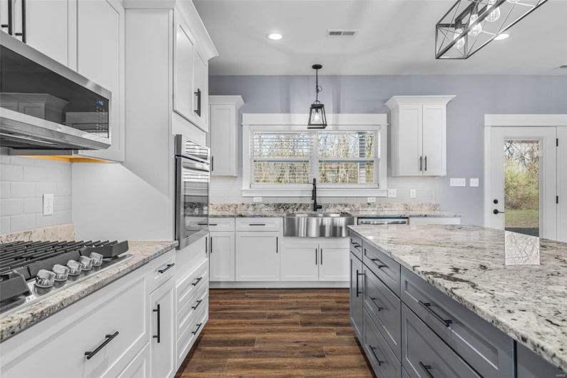 Kitchen featuring a sink, appliances with stainless steel finishes, gray cabinetry, visible vents, and white cabinets