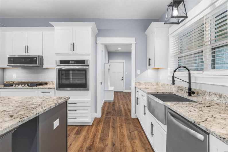 Kitchen featuring a sink, white cabinetry, appliances with stainless steel finishes, and dark wood-type flooring
