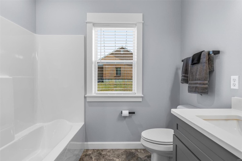 Full bathroom featuring baseboards, a wealth of natural light, toilet, and vanity