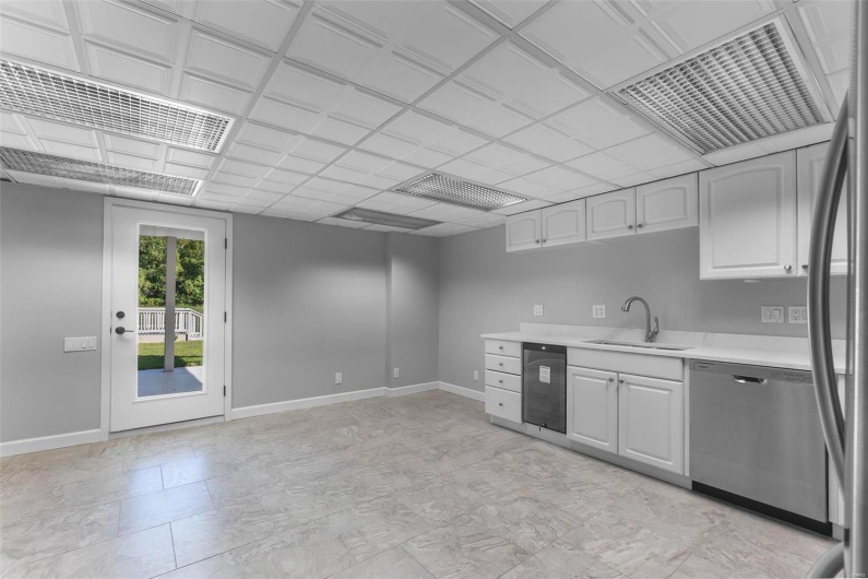 Kitchen featuring stainless steel appliances, white cabinetry, and sink
