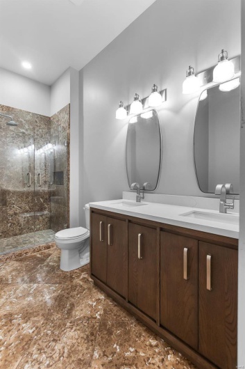 Bathroom with an enclosed shower, vanity, and toilet
