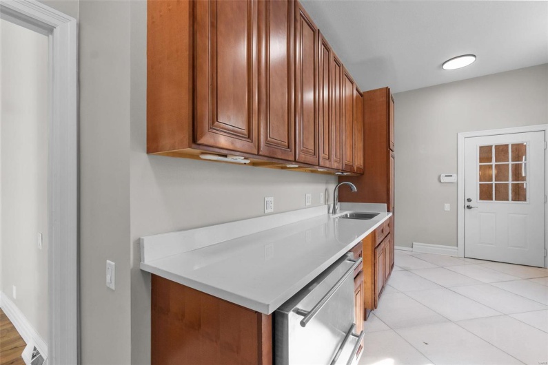 Kitchen with light tile patterned floors, dishwasher, and sink