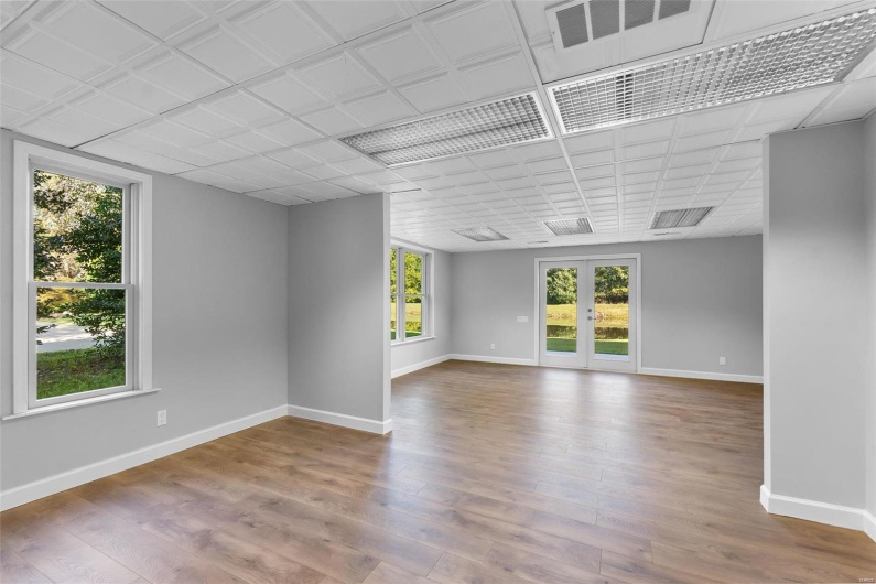 Empty room featuring wood-type flooring, french doors, and a wealth of natural light