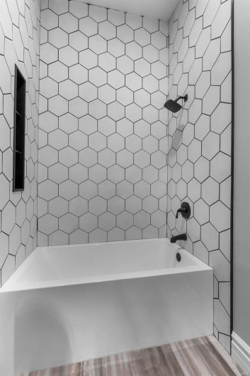 Bathroom featuring tiled shower / bath combo and hardwood / wood-style floors