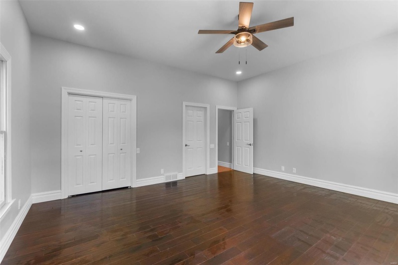 Unfurnished bedroom featuring dark hardwood / wood-style floors and ceiling fan