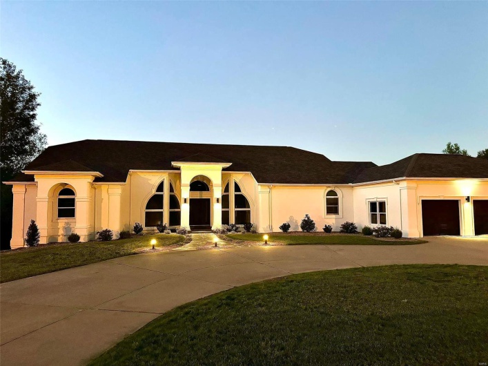 Mediterranean / spanish-style home featuring a garage and a lawn