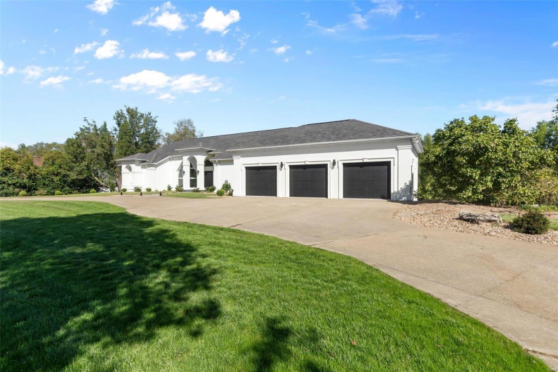 View of front of property featuring a front lawn and a garage