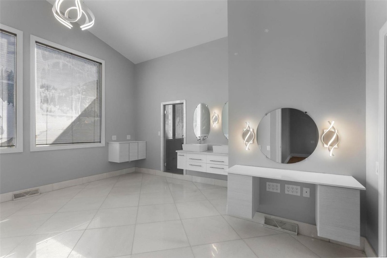Bathroom featuring tile patterned flooring, lofted ceiling, and vanity