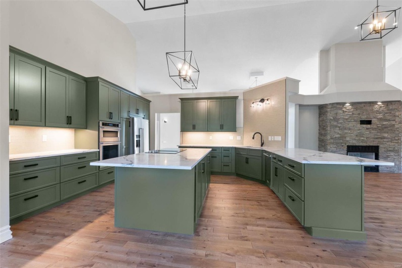 Kitchen featuring pendant lighting, high vaulted ceiling, and green cabinetry