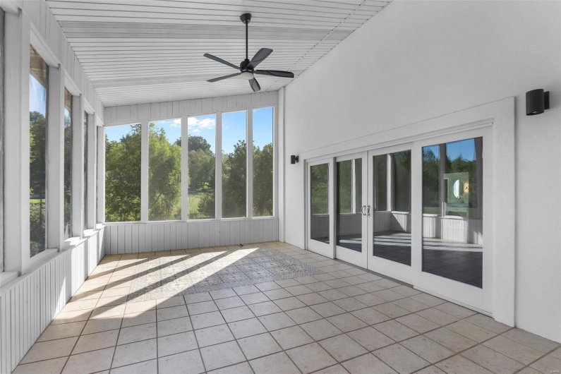 Unfurnished sunroom featuring vaulted ceiling and ceiling fan