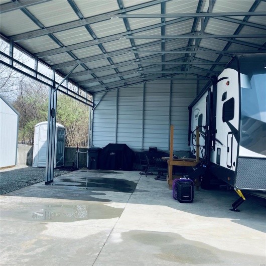 View of vehicle parking with a storage shed