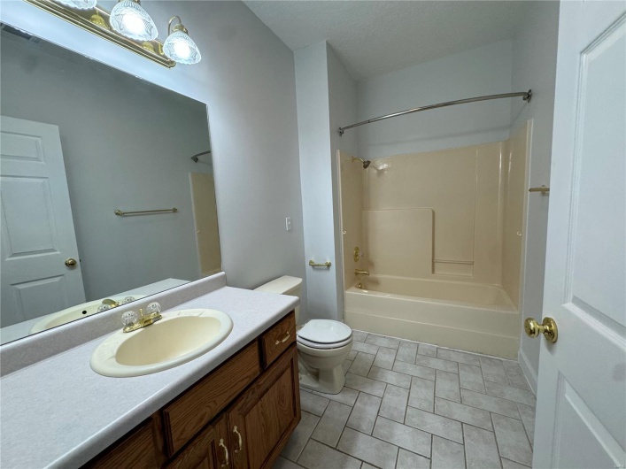 Bathroom with shower / bathing tub combination, toilet, and vanity
