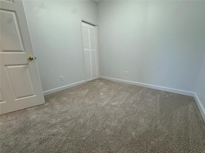 Unfurnished bedroom with carpet flooring, baseboards, and a closet