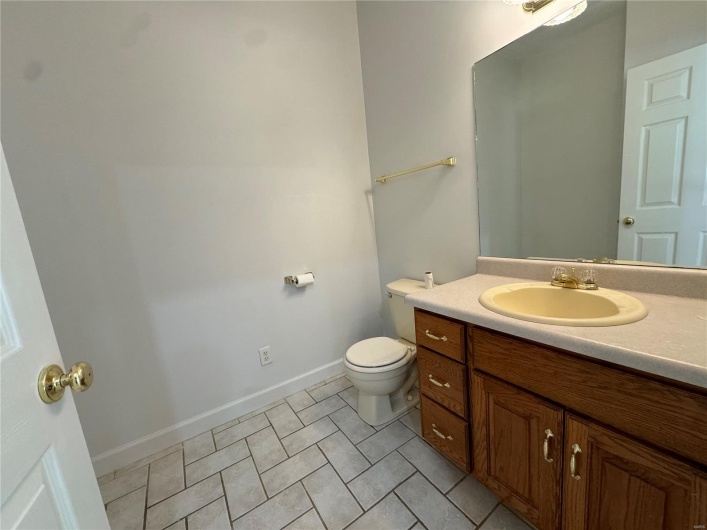 Bathroom with toilet, vanity, tile patterned floors, and baseboards