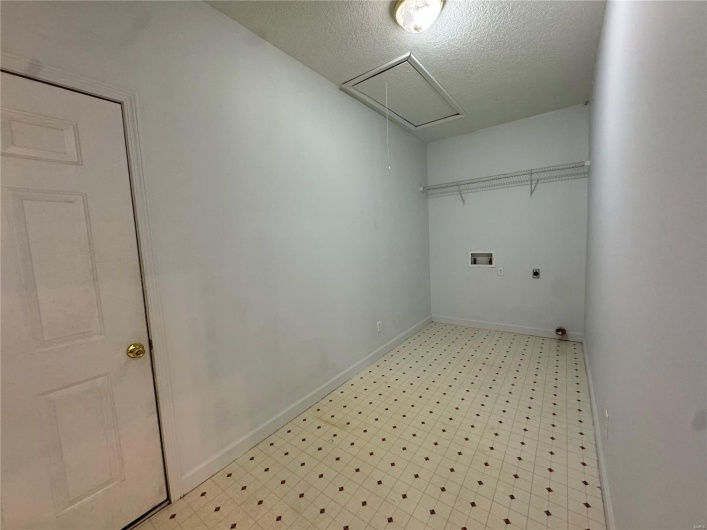 Clothes washing area with attic access, washer hookup, light floors, hookup for an electric dryer, and laundry area