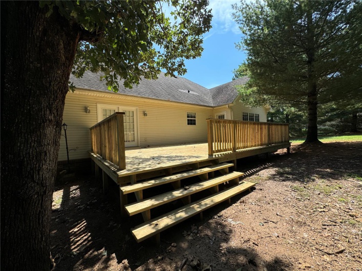 Back of house featuring roof with shingles, french doors, and a deck