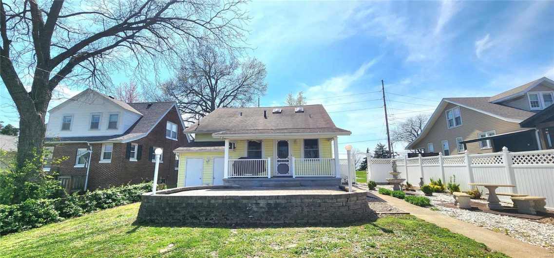Back of property with fence, a porch, and a yard