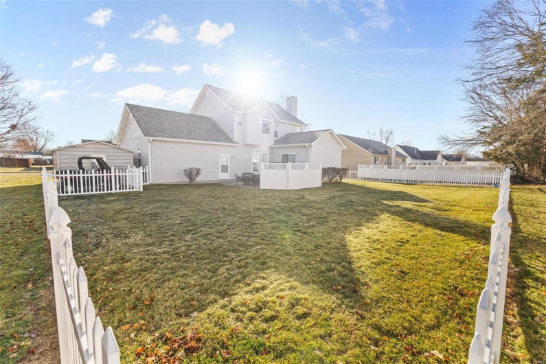 Rear view of house with a yard and fence