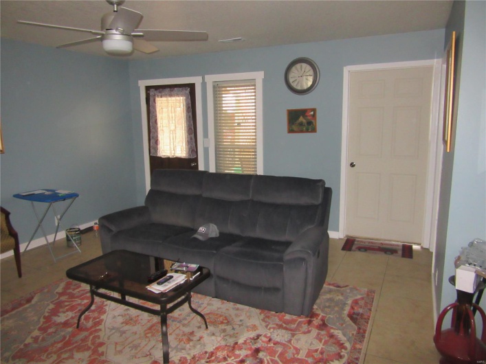 Tiled living room with baseboards and a ceiling fan